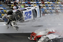 Kyle Larson (32) goes airborne and into the catch fence during a multi-car crash involving Justin Allgaier (31), Brian Scott (2) and others during the final lap of the NASCAR Nationwide Series auto race at Daytona International Speedway, Saturday, Feb. 23, 2013, in Daytona Beach, Fla. Larson's crash sent car parts and other debris flying into the stands injuring spectators. (AP Photo/John Raoux)