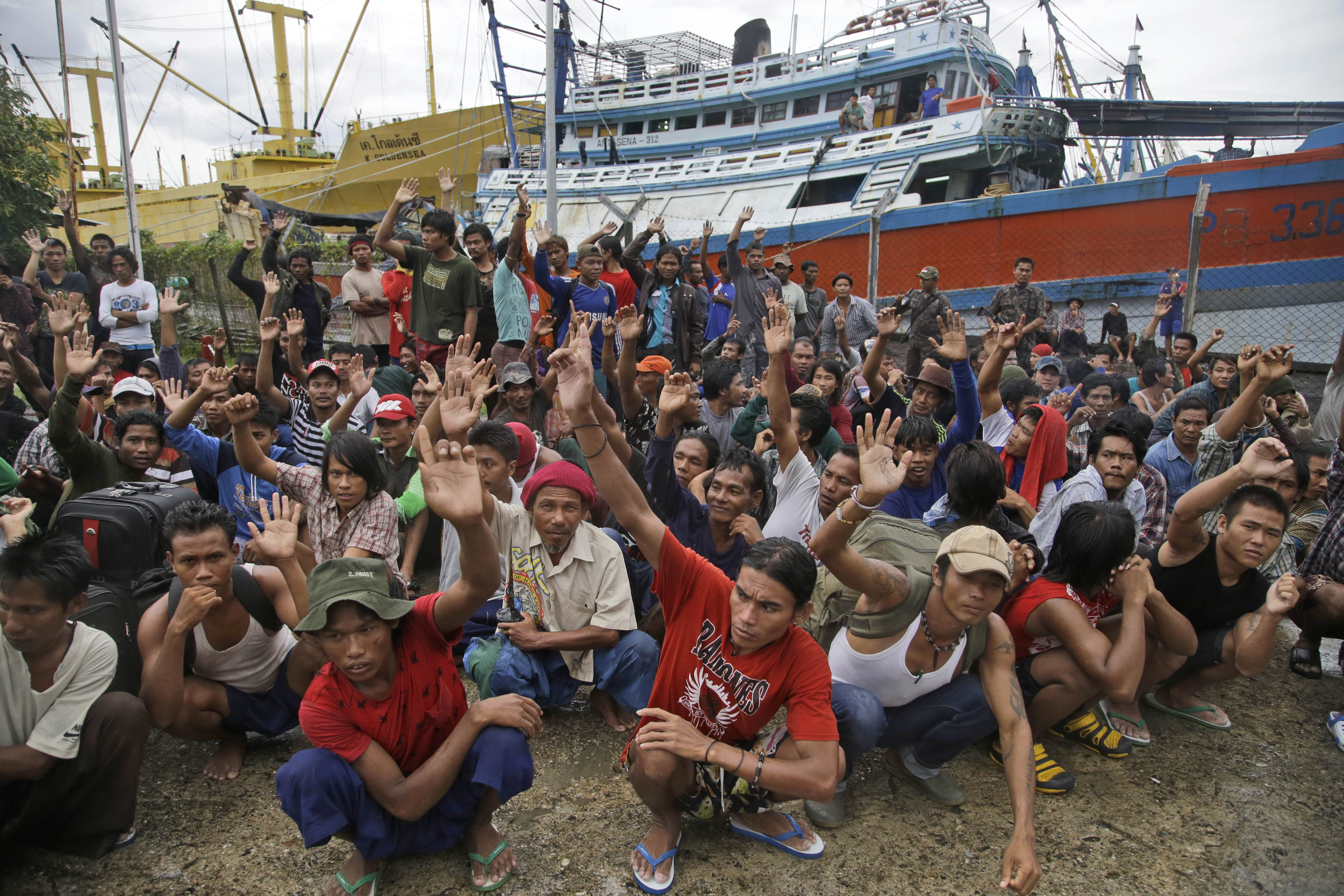 FILE - In this Friday, April 3, 2015 file photo, Burmese fishermen raise their hands as they are asked who among them wants to go home at the compound of Pusaka Benjina Resources fishing company in Benjina, Aru Islands, Indonesia. On Thursday, March 10, 2016, five Thai fishing boat captains and three Indonesians were sentenced to three years in jail for human trafficking in connection with slavery in the seafood industry. The suspects were arrested in the remote island village of Benjina in May 2015 after the abuse was revealed by The Associated Press in a report two months earlier. (AP Photo/Dita Alangkara)