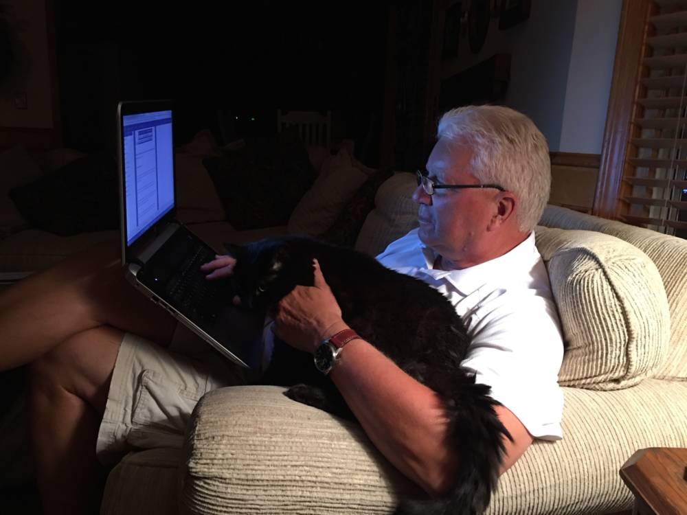 Paul Stevens and Felix the cat work on the newsletter. (Photo courtesy Paul Stevens)