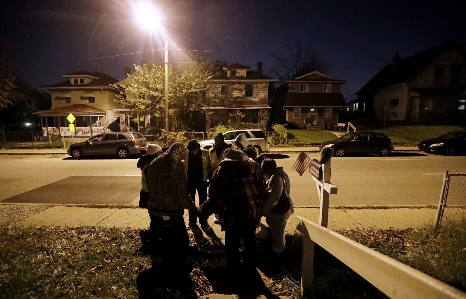 Members of the Ten Point Coalition pray with a family during a walk in 2017 in Indianapolis. Four nights a week, they walk their streets, talking to young people and trying to point them away from trouble. (AP Photo/Darron Cummings)