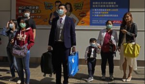 People wearing face masks wait at a pedestrian crosswalk in Hong Kong on Saturday. (AP Photo/Vincent Yu)