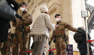 Police officers and soldiers check passengers leaving from Milan main train station, Italy, March 9, 2020. Italy took a page from China's playbook, attempting to lock down 16 million people — more than a quarter of its population — to halt the relentless march of the new coronavirus across Europe. (AP Photo/Antonio Calanni)