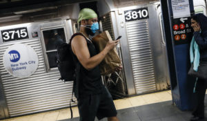 A commuter wears a face mask in the New York City transit system, Monday, March 9, 2020, in New York. New York continued grappling Monday with the new coronavirus, as case numbers, school closings and other consequences grew. (AP Photo/John Minchillo)