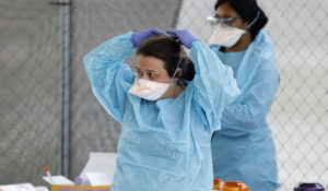 Raeanne Castillo with Roper St. Francis Healthcare puts on a protective mask at the hospital's North Charleston office Monday, March 16, in North Charleston, South Carolina (AP Photo/Mic Smith)