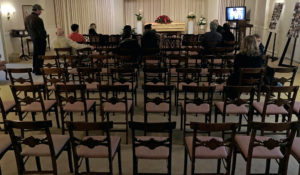 This March 18, 2020 photo shows a funeral that was affected by new rules put in place due to the coronavirus outbreak in Milwaukee, Wisconsin. Wisconsin Gov. Tony Evers restricted gatherings to less than 10 people the day before. (AP Photo/Carrie Antlfinger)