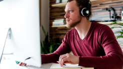 Man at computer wearing headphones