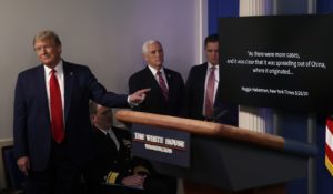 President Donald Trump points to a White House-produced video during a briefing about the coronavirus on Monday. (AP Photo/Alex Brandon)