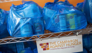 Shopping bags full of groceries line a shelf at The Campaign Against Hunger food pantry, Thursday, April 16, 2020, in the Bedford-Stuyvesant neighborhood of the Brooklyn borough of New York. Food pantries stay busy even in the best of economic times; the coronavirus pandemic has prompted a spike in demand as millions of people find themselves furloughed, laid off or with businesses that have suffered huge financial blows. (AP Photo/Mary Altaffer)