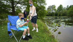 Sometimes you have to do something other than watch the news. In this photo, a Texas woman and her son go fishing. (AP Photo/David J. Phillip)