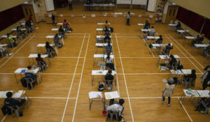 Students wearing masks to help stop the spread of the new coronavirus, sit for the Diploma of Secondary Education (DSE) exams at a school in Hong Kong, Friday, April 24, 2020. Temperature checks and social distancing measures to avoid the spread of COVID-19 had been put in place in the schools for over 50,000 candidates who will sit for the DSE examination this year. (Jerome Favre/Pool Photo via AP)