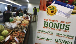 In this Friday, March 17, 2017 photo a sign advertises a program that allows food stamp recipients to use their EBT cards to shop at a farmer's market in Topsham, Maine. (AP Photo/Robert F. Bukaty)