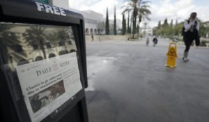 A headline in the San Diego State University Daily Aztec newspaper reads, "Classes to go online-only due to coronavirus fears," Thursday, March 12, 2020, in San Diego.  (AP Photo/Gregory Bull)