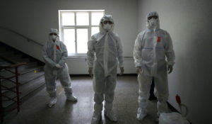 Health officials wearing protective gears prepare to spray disinfectant as a precaution against the new coronavirus ahead of school reopening at a high school in Seoul, South Korea, Monday, May 11, 2020. (AP Photo/Lee Jin-man)