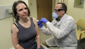 A pharmacist gives Jennifer Haller, the first shot in the first-stage safety study clinical trial of a potential vaccine for COVID-19. The vaccine, by Moderna Inc., generated antibodies similar to those seen in people who have recovered from COVID-19. (AP Photo/Ted S. Warren, File)