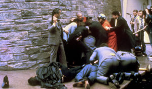 As a U.S. secret service agent with an automatic weapon watches over James Brady, the president's secretary, after being wounded in an attempt on the life of President Ronald Reagan, in Washington, D.C., March 30, 1981.  A Washington, D.C. policeman, Thomas Delahanty, lies to the left after also being shot. (AP Photo/Ron Edmonds)