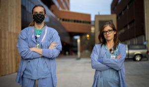 6:15 a.m. Shai Schwartz, left, a Dialysis Technician, and Calie Shemwell, right, a Dialysis Nurse, pose for a portrait before heading into work. "I know some are a bit worried about low supplies with masks and other items," said Schwartz, "But we still make due with what we have and do our best to deliver our best patient care." (Jack Rodgers/Minnesota Daily)