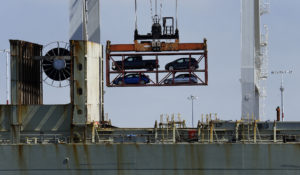 A crane transporting vehicles produced in Mexico operates on a container ship at the Port of Oakland. The USMCA trade agreement contains new mandates that will drive higher wages in Mexico. (AP Photo/Ben Margot, File)