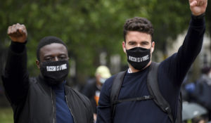 Protestors make a fist during protests in London. (AP Photo/Alberto Pezzali)