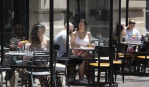 Partitions separate restaurant patrons at tables set up on the sidewalk, June 12, in Boston. In a New York Times poll of epidemiologists and infectious disease specialists, only 16% said they expect to eat at a restaurant this summer. (AP Photo/Michael Dwyer)