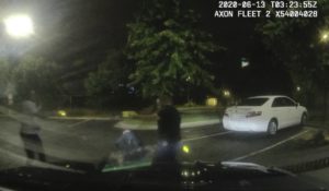 This screengrab taken from dashboard camera video provided by the Atlanta Police Department shows Rayshard Brooks, left, and officer Garrett Rolfe pointing Tasers at one another, while officer Devin Brosnan is seen getting up after a struggle among the three men in the parking lot of a Wendy's restaurant last week in Atlanta. (Atlanta Police Department via AP)