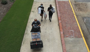 A family carries their belongings while college students begin moving in for the fall semester at N.C. State University in Raleigh, N.C., Friday, July 31. (AP Photo/Gerry Broome)