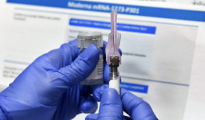 Nurse Kathe Olmstead prepares a shot as the world's biggest study of a possible COVID-19 vaccine, developed by the National Institutes of Health and Moderna Inc., gets underway Monday, July 27, 2020, in Binghamton, N.Y. (AP Photo/Hans Pennink)