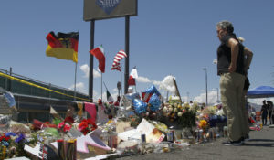 Mourners visit a makeshift memorial near the Walmart in El Paso, Texas, where 22 people were killed in a mass shooting that targeted Latinos. White supremacists and other far-right extremists killed at least 38 people in the U.S. in 2019, the sixth deadliest year for violence by all domestic extremists since 1970. (AP Photo/Cedar Attanasio, File)