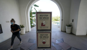 A woman wears a mask as she walks on campus at San Diego State University, Wednesday, Sept. 2, 2020, in San Diego. San Diego State University on Wednesday halted in-person classes for a month after dozens of students were infected with the coronavirus. (AP Photo/Gregory Bull)