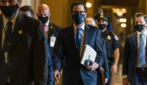 Treasury Secretary Steven Mnuchin, center, walks from the office of Senate Majority Leader Sen. Mitch McConnell as he leaves the Capitol, Wednesday. Mnuchin earlier met with House Speaker Nancy Pelosi of California. (AP Photo/Manuel Balce Ceneta)