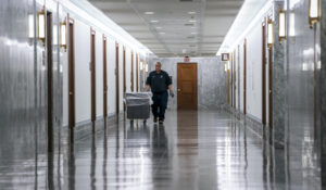 A workman walks through the empty corridors of the Dirksen Senate Office Building in Washington, Wednesday, March 18, 2020. (AP Photo/J. Scott Applewhite)
