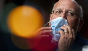 CDC Director Dr. Robert Redfield puts his mask back on after speaking at a Senate hearing. The CDC has stirred confusion, by posting, and then taking down, and now reposting an apparent change in its position on how easily the coronavirus can spread through the air. (AP Photo/Andrew Harnik, Pool)