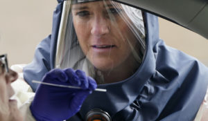 Salt Lake County Health Department public health nurse Lee Cherie Booth performs a coronavirus test outside the Salt Lake County Health Department Friday, Oct. 23, 2020, in Salt Lake City. (AP Photo/Rick Bowmer)