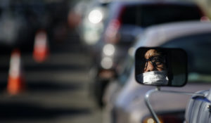 Guadalupe Guillen waits in line for food at a distribution center Thursday, July 23, 2020, in Brawley, Calif. Imperial County's poverty rate of 21% is among California's highest, putting more pressure on an area hard-hit by the coronavirus. (AP Photo/Gregory Bull)