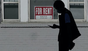 A man walks in front of a "For Rent" sign in a window of a residential property in San Francisco, Tuesday, Oct. 20, 2020. (AP Photo/Jeff Chiu)
