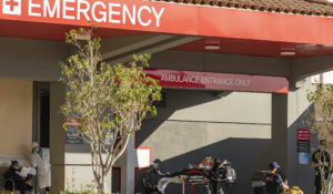 An unidentified patient receives oxygen on a stretcher, while Los Angeles Fire Department Paramedics monitor him outside CHA Hollywood Presbyterian Medical Center in Los Angeles Friday, Dec. 18, 2020. (AP Photo/Damian Dovarganes)