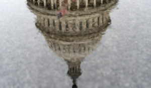 The U.S. Capitol has a painterly effect as it is seen reflected through a puddle as raindrops fall during a rainstorm, Thursday, Dec. 24, 2020, in Washington. (AP Photo/Jacquelyn Martin)