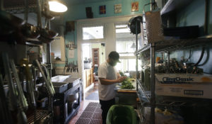 Jesus Cruz, prep cook at Blue Plate, covers his face with a mask while working in the kitchen at the San Francisco restaurant, May 14, 2020. Blue Plate was able to keep most staff employed due to the first PPP. The second one may benefit restaurants even more. (AP Photo/Jeff Chiu)