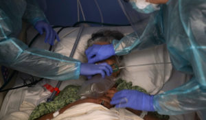 Two nurses put a ventilator on a patient in a COVID-19 unit at St. Joseph Hospital in Orange, Calif. Thursday, Jan. 7, 2021. (AP Photo/Jae C. Hong)