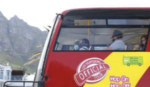 Tourists wearing face masks to safeguard against coronavirus aboard a touring bus in Cape Town, South Africa Tuesday, Dec. 29, 2020. (AP Photo/Nardus Engelbrecht)