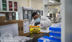 A lab technician works on blood samples taken from people taking part in a Johnson & Johnson COVID-19 vaccine test at the Ndlovu clinic's lab in Groblersdal, South Africa, Thursday, Feb. 11, 2021. (AP Photo/Jerome Delay)