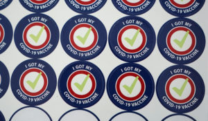 Stickers given to people getting vaccinated for COVID-19 are shown Tuesday, Feb. 23, 2021, at the VA Puget Sound Health Care System campus in Seattle. (AP Photo/Ted S. Warren)