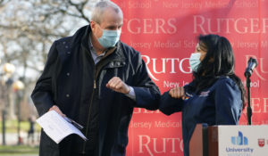 New Jersey Gov. Phil Murphy bumps elbows with emergency room nurse Maritza Beniquez — the first in New Jersey to recieve a vaccine — at a vaccine clinic at Rutgers New Jersey Medical School in Newark, N.J., Tuesday, Dec. 15, 2020. Rutgers will require all in-person students to get the vaccine. (AP Photo/Seth Wenig)
