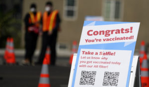 A selfie station congratulates people for getting vaccinated with the Moderna COVID-19 vaccine at a site for Los Angeles School District employees in the parking lot of SOFI Stadium Tuesday, March 2, 2021, in Inglewood, Calif. (AP Photo/Marcio Jose Sanchez)