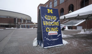 A sign for a COVID vaccine clinic is shown at University of Michigan Stadium in Ann Arbor, Mich., Wednesday, Feb. 10, 2021. (AP Photo/Paul Sancya)