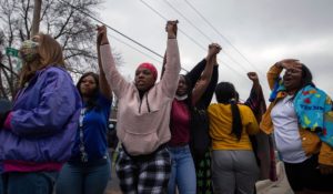 People raise their arms in protest on Sunday in Brooklyn Center, Minn., following the shooting death of a Black man by police. (AP Photo/Christian Monterrosa)