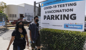 Rosa Vargas and her son, 9th grade student Victor Loredo, 14, walk home after getting tested at a Los Angeles Unified School District COVID-19 testing and vaccination site in East Los Angeles Thursday, April 15, 2021. (AP Photo/Damian Dovarganes)