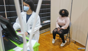 Keidy Ventura, 17, talks to the medical personnel after receiving her first dose of the Pfizer COVID-19 vaccine in West New York, N.J., Monday, April 19, 2021. Teens as young as 12 may soon be approved to receive the vaccine. (AP Photo/Seth Wenig)