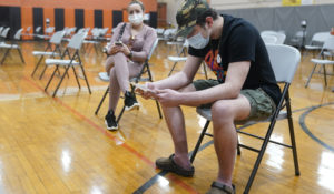 Alejandro Garcia, 16, waits with his mother, Adrey Garcia, for 15 minutes after he received his first dose of the Pfizer COVID-19 vaccine in West New York, N.J., Monday, April 19, 2021. (AP Photo/Seth Wenig)