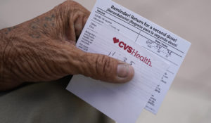 A man holds his vaccination reminder card after having received his first shot at a pop-up vaccination site next to Maximo Gomez Park, also known as Domino Park, Monday, May 3, 2021, in the Little Havana neighborhood of Miami. (AP Photo/Wilfredo Lee)