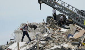 Rescue worker walk among the rubble where a wing of a 12-story beachfront condo building collapsed, Thursday, June 24, 2021, in the Surfside area of Miami.  (AP Photo/Lynne Sladky)